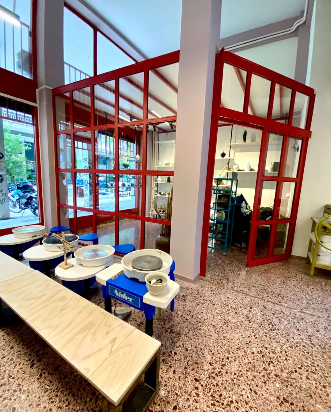Studio workspace with pottery wheels and red-framed windows